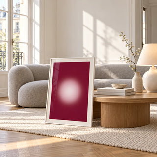 Burgundy Aura Print, framed and leaning against a coffee table in a bright living room