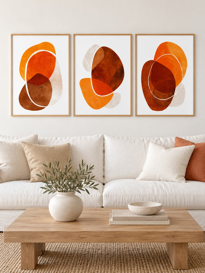 Burnt Orange Abstract Wall Art hung at eye level above a white linen sofa: Organic Curves, Dynamic Shapes and Shape Symphony shown framed side by side (frames not included)