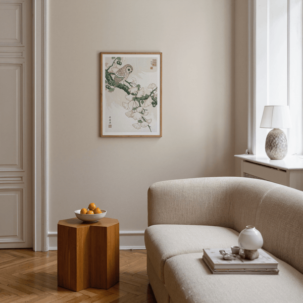 Living room with beige sofa, wooden side table, and framed artwork on the wall.