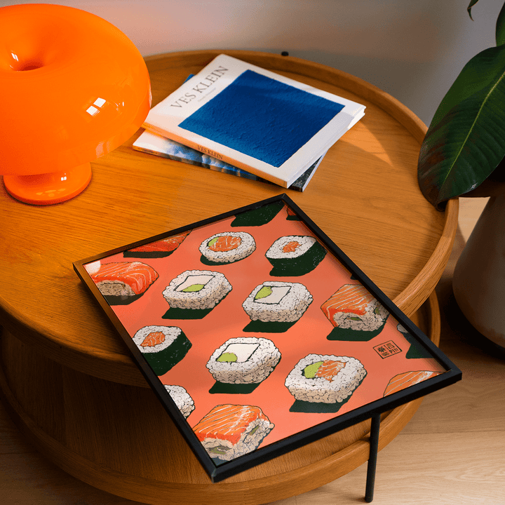 Framed Sushi Wall poster leaning on a wooden table with sushi illustrations on orange background