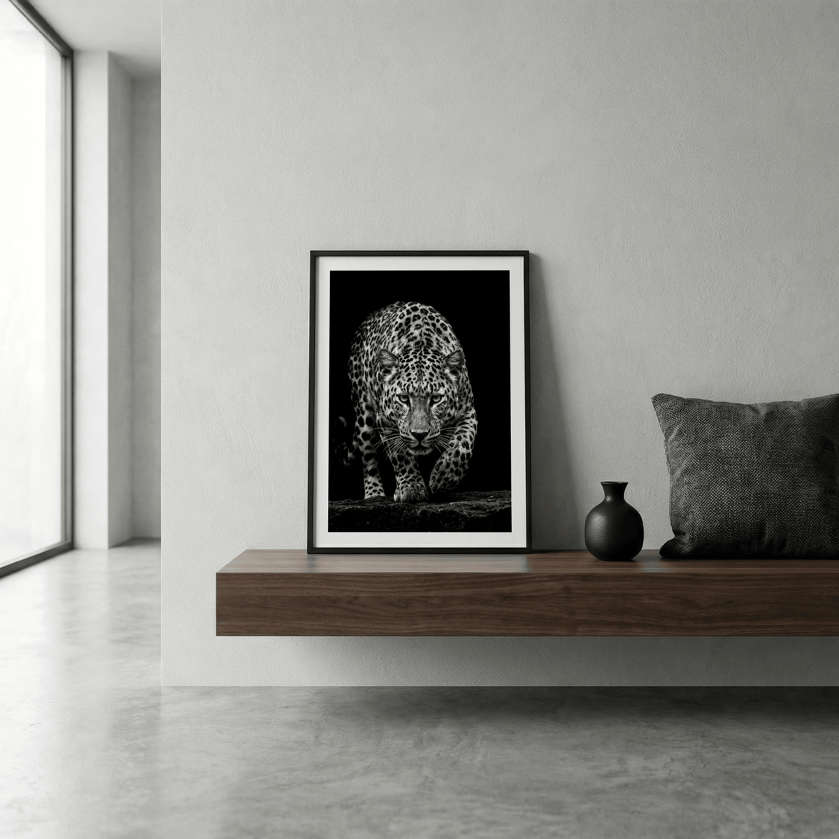 Studio-style animal print of a leopard stepping forward over a low rock ledge