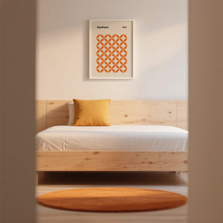 Framed artwork of orange minimalist print in a light-filled studio.