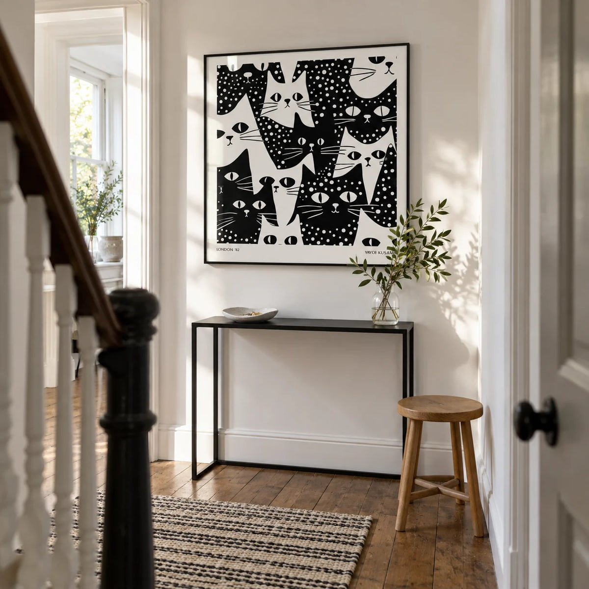 Cat Art Black and White, framed on the wall of a bright narrow hallway in a Victorian terrace with white painted walls and restored timber floorboards