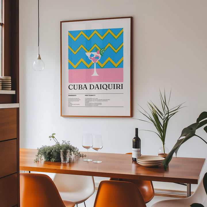 Alcohol artwork print of a colourful daiquiri cocktail in a wooden frame above a dining table with glasses
