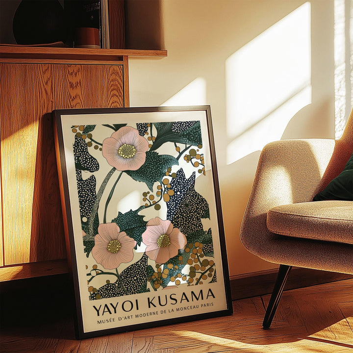 Pink wall art for bedroom leaning on a wooden floor showing pink flowers and green leaves near a chair