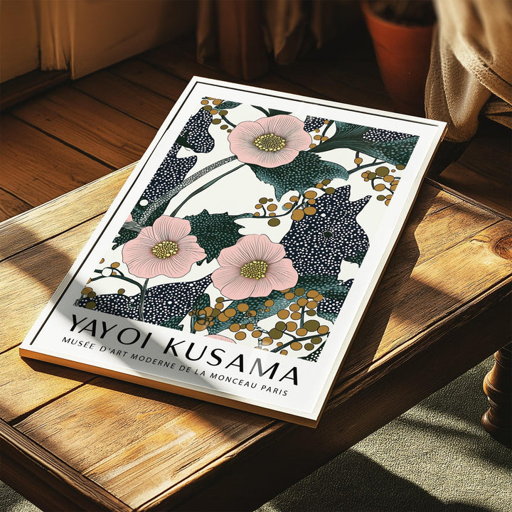 Pink wall art for bedroom with pink flowers and berries print leaning on a wooden table