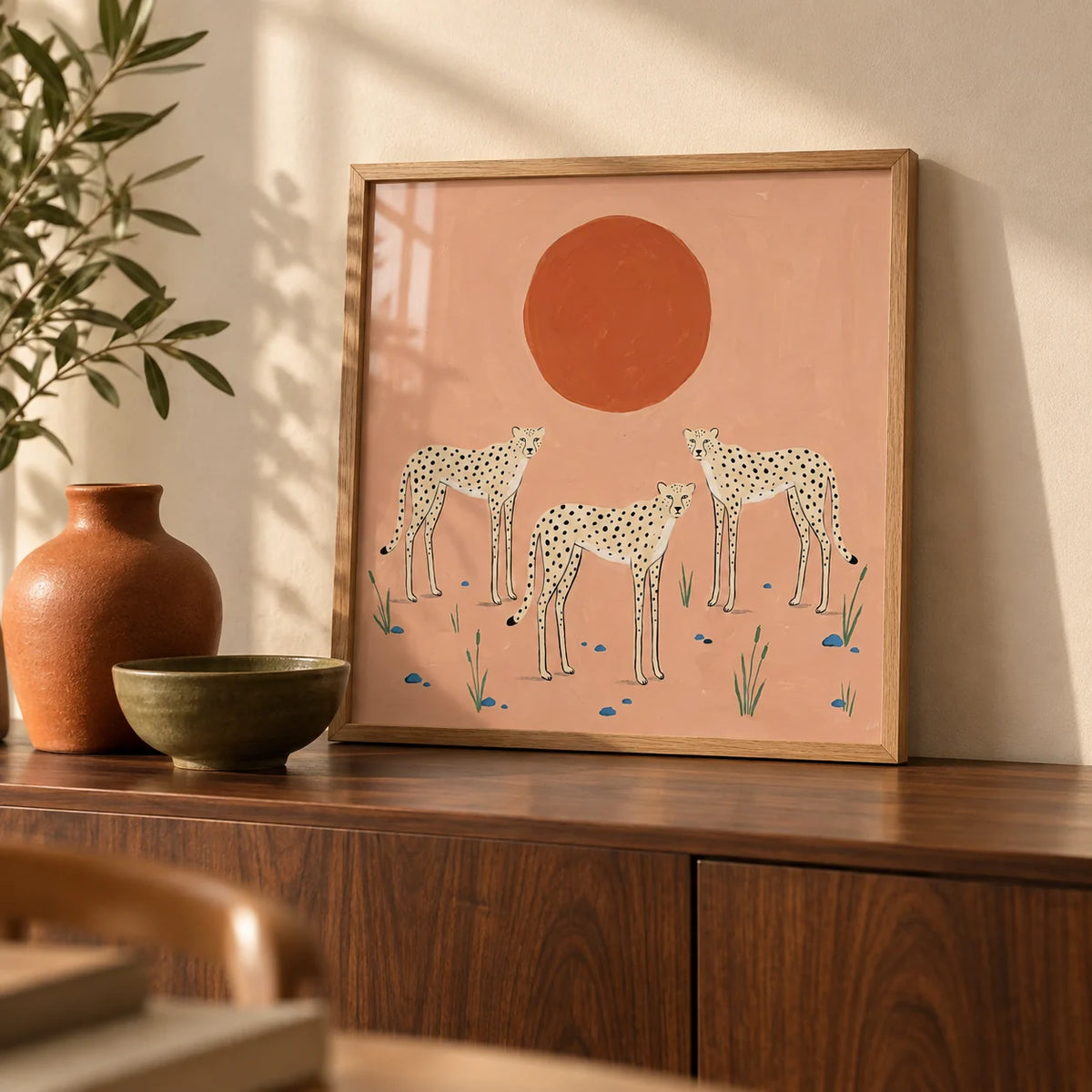 Cheetah Art Print, a small A4 framed print leaning on a walnut sideboard in a living room