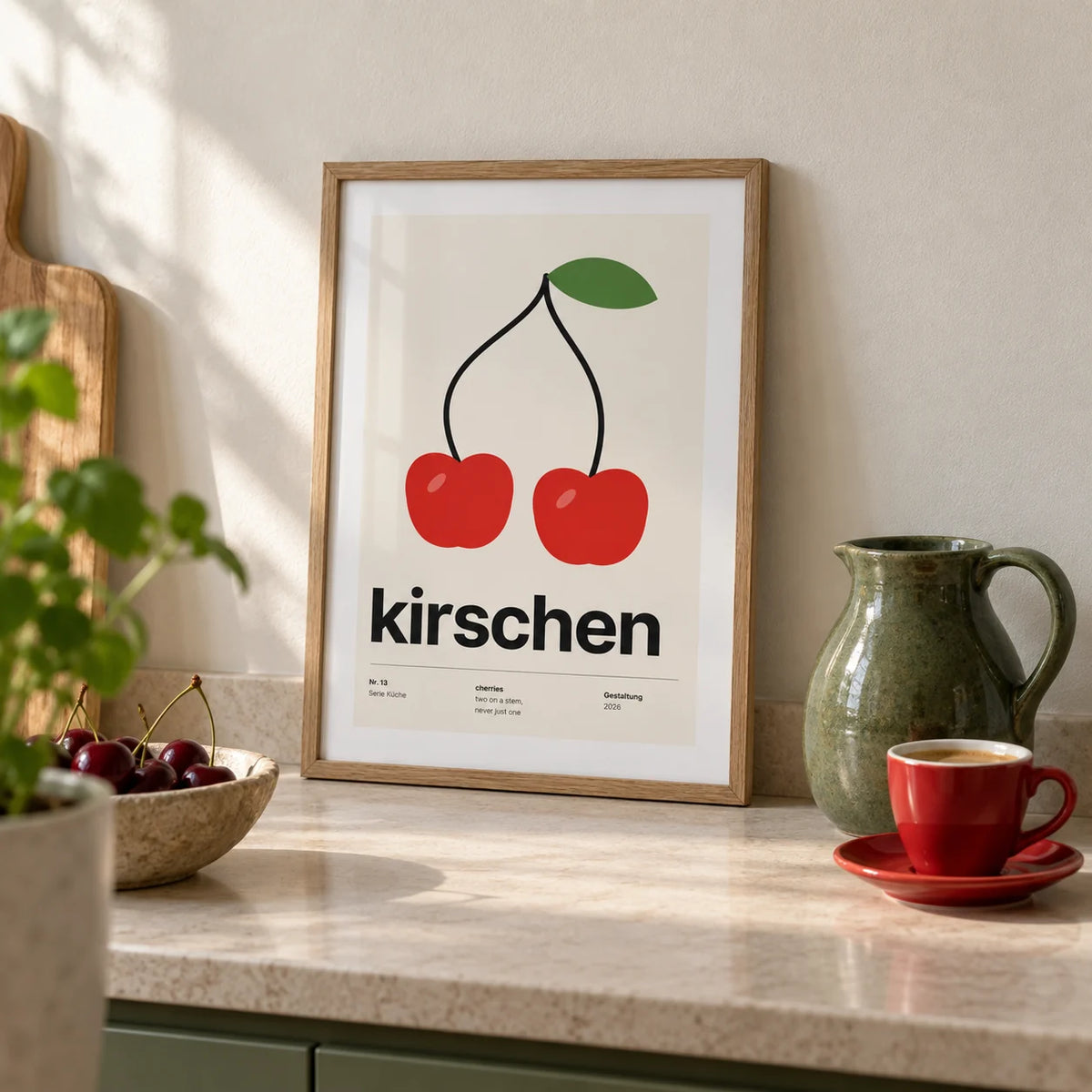 Cherry Print, a small A4 framed print leaning on a pale stone kitchen worktop