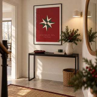Christmas Star Print, framed on the wall of a welcoming hallway in a design-led UK flat with warm white walls and a plain stone floor