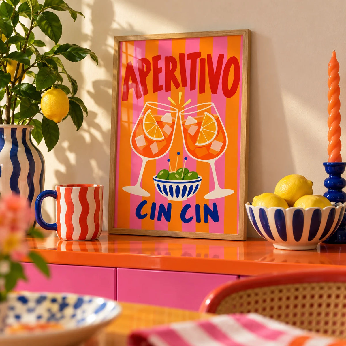 Cin Cin Print, a small A4 framed print leaning on a colourful lacquered shelf in a living room