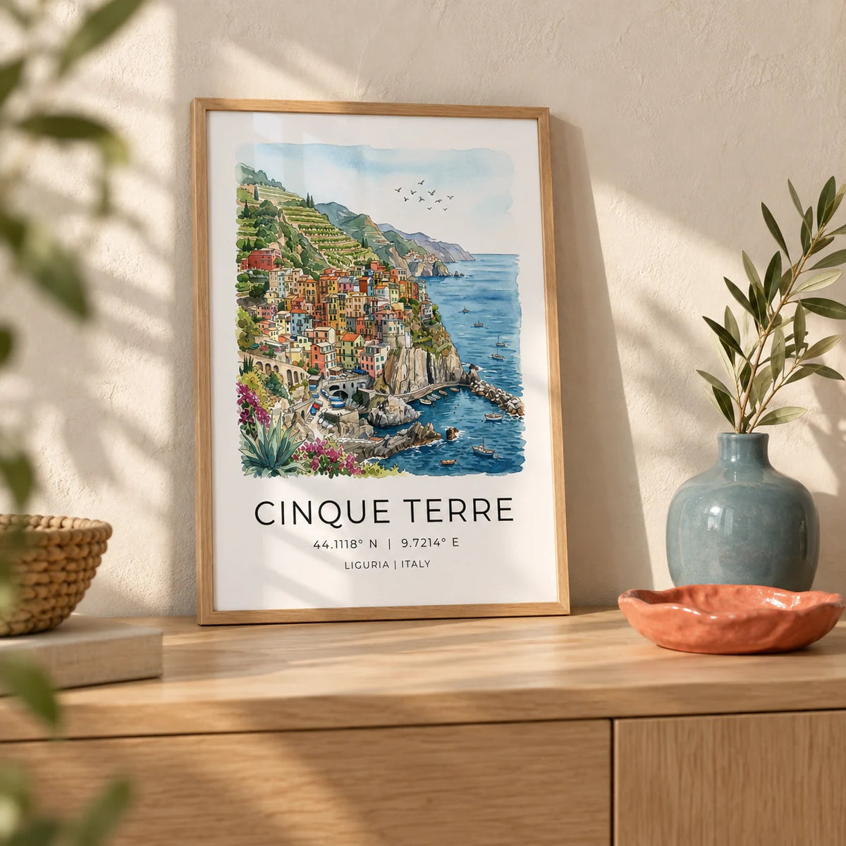 Cinque Terre Art Print, a small A4 framed print leaning on a pale oak sideboard in a living room