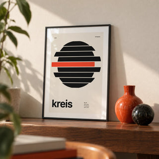 Circle Print, a small A4 framed print leaning on a walnut shelf in a living room
