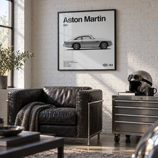 Classic British Grand Tourer Poster, framed on the wall of a stylish converted garage den with a white painted brick wall and a polished concrete floor in a living room
