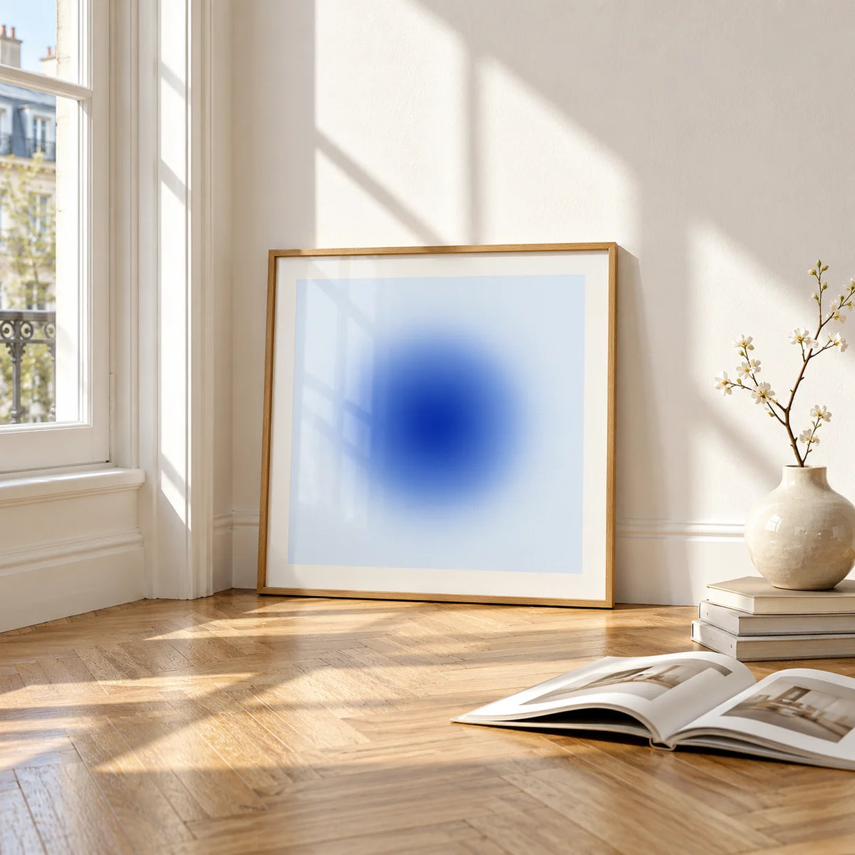 Cobalt Blue Wall Art, framed and leaning on the parquet floor of a bright living room