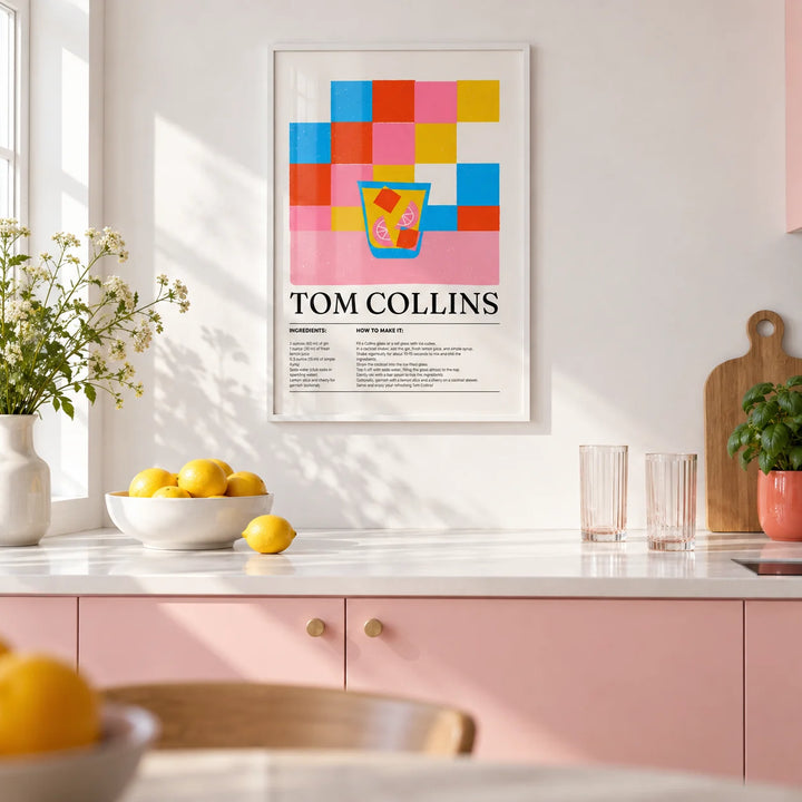Colorful Bar Prints, framed on the wall of a bright kitchen with plain soft pink cabinets and a white worktop