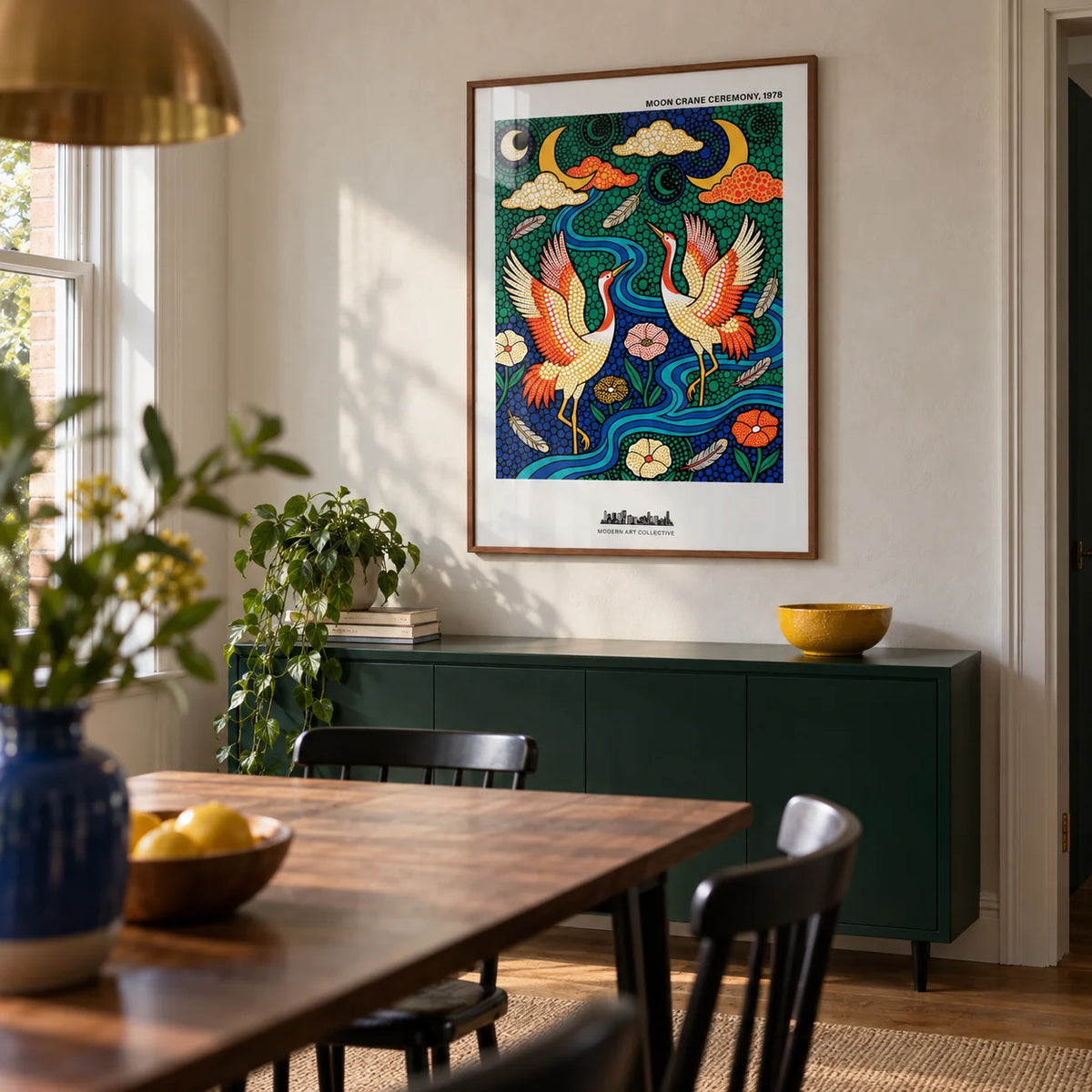 Colorful Crane Poster, framed on the wall of a contemporary dining room in a renovated UK terrace with a pale plaster wall and a solid deep green sideboard