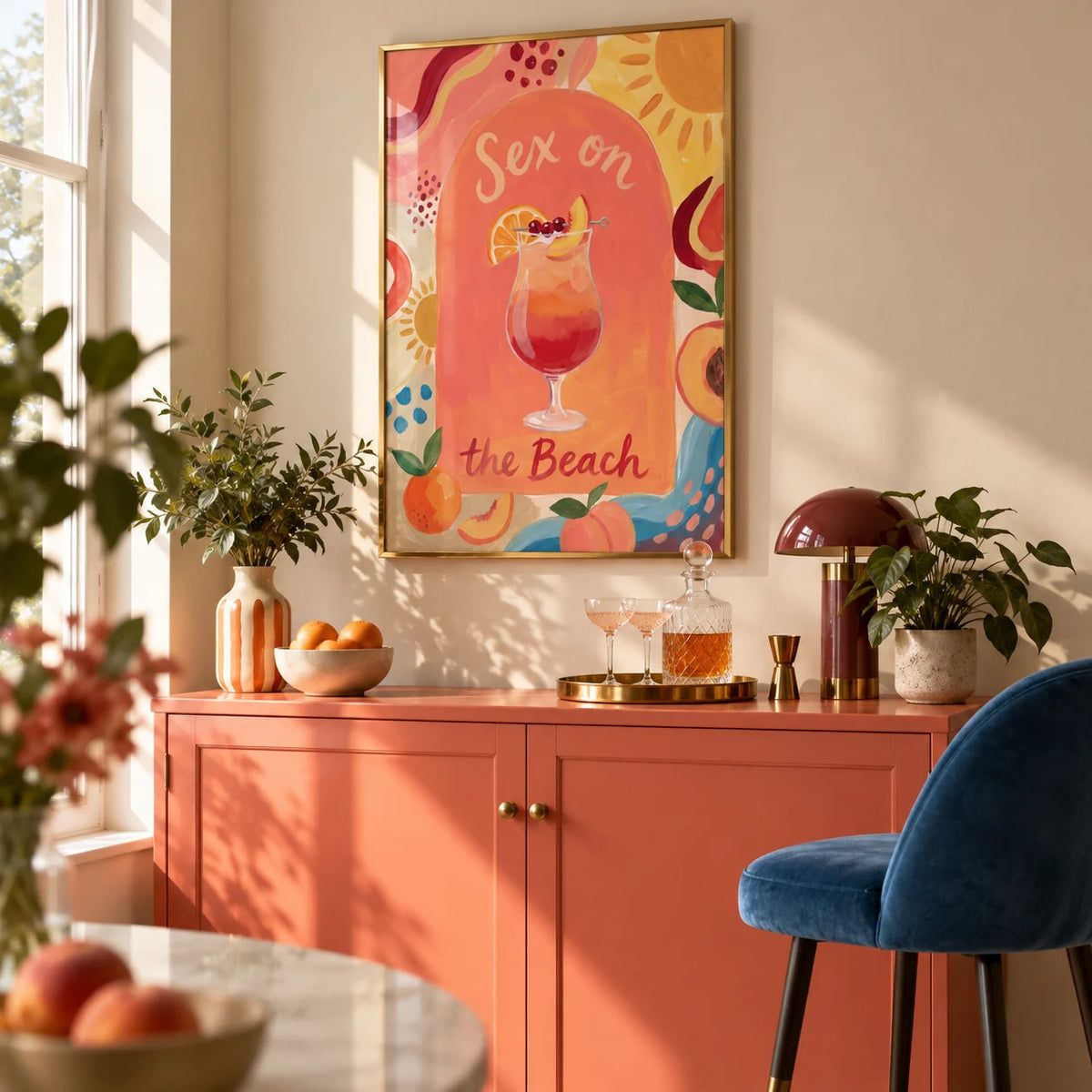 Colorful Drink Poster, framed on the wall of a compact home bar in a modern UK flat with a warm cream wall and a solid coral painted drinks cabinet in a living room