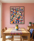 Dining room with a colorful Mexican wall art piece on a pink wall, wooden table, and chairs.