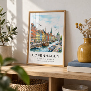 Copenhagen Canal Wall Art, a small A4 framed print leaning on a pale oak shelf in a living room