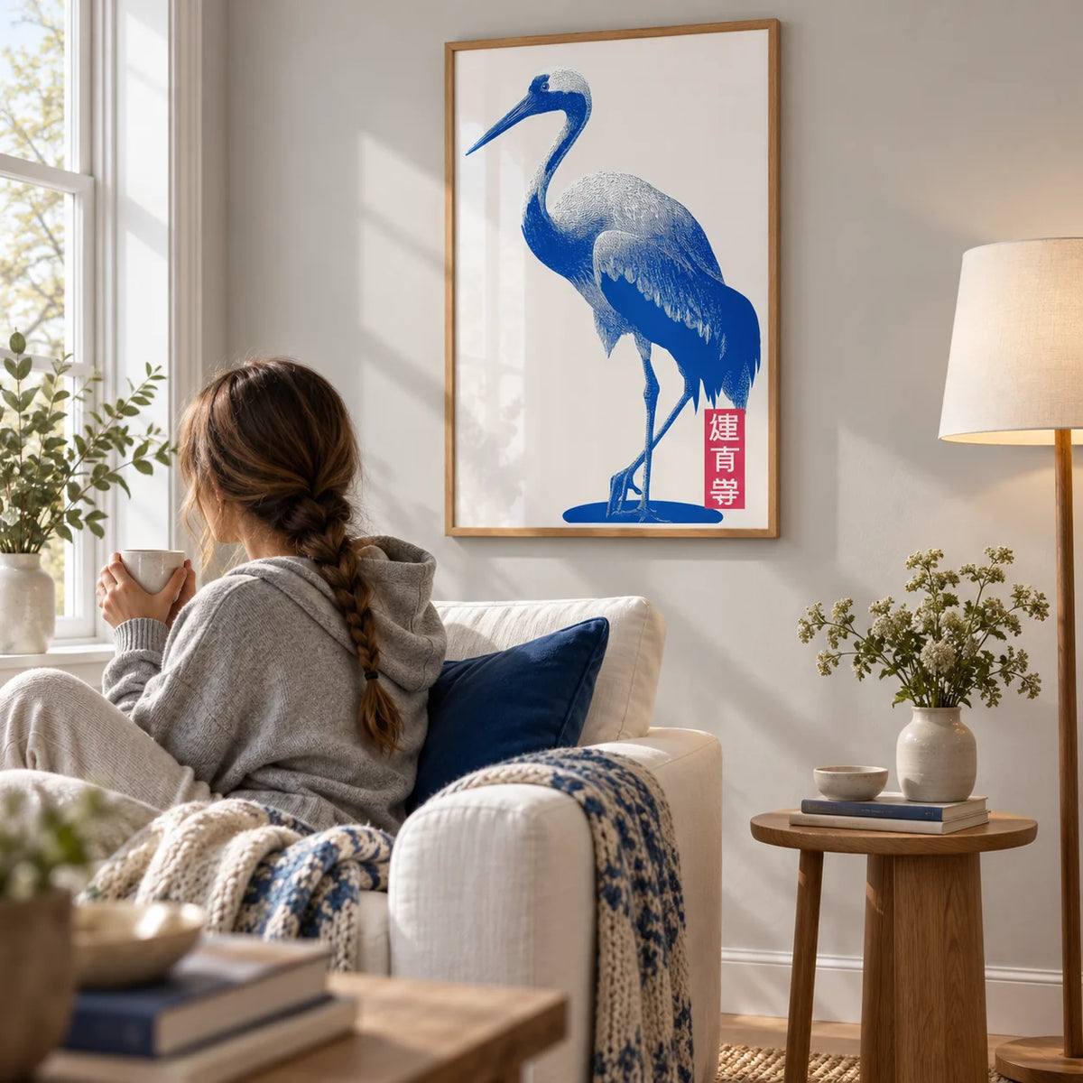 Crane Wall Art, framed on the wall of a quiet reading corner with a pale grey wall in a living room