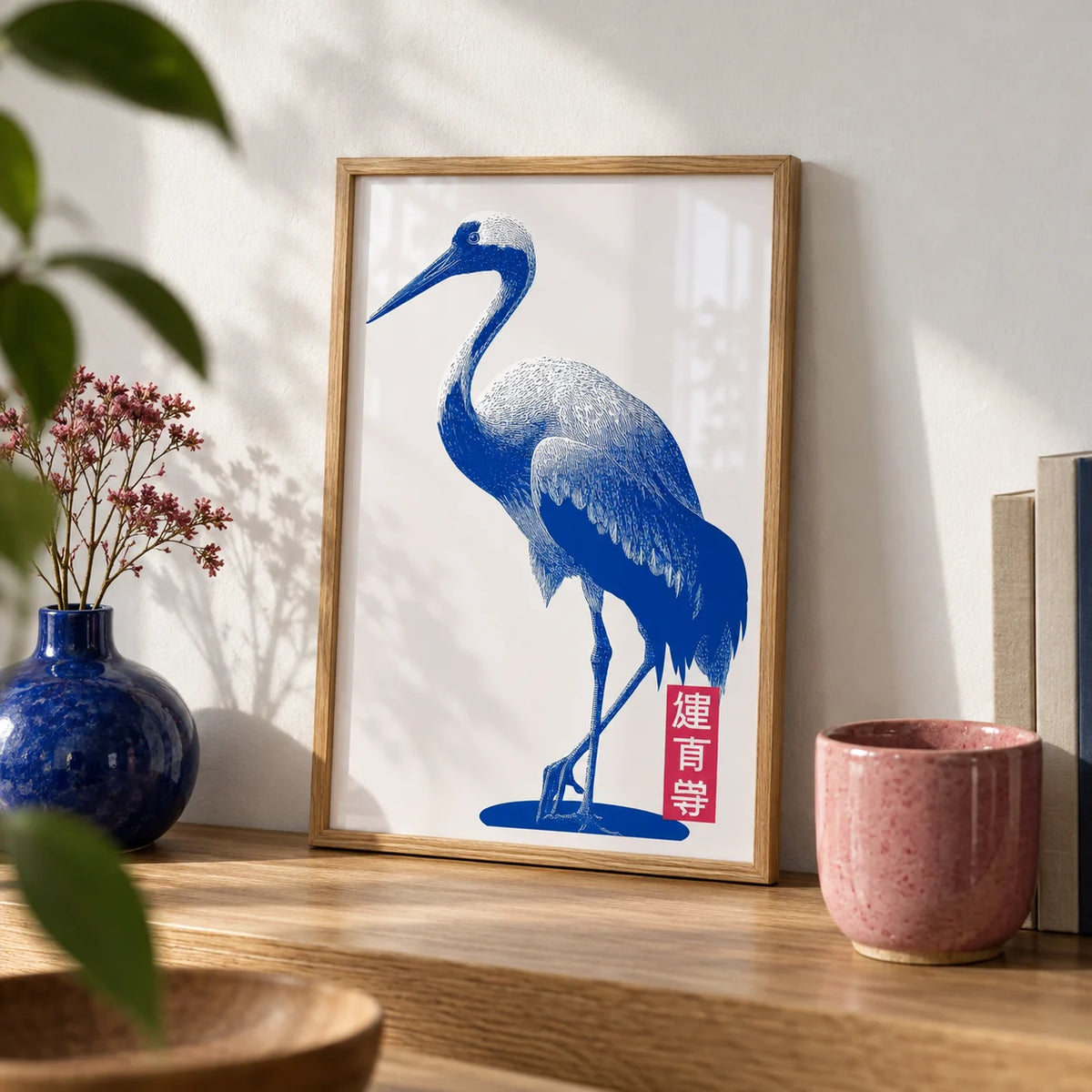 Crane Wall Art, a small A4 framed print leaning on an oak shelf in a living room