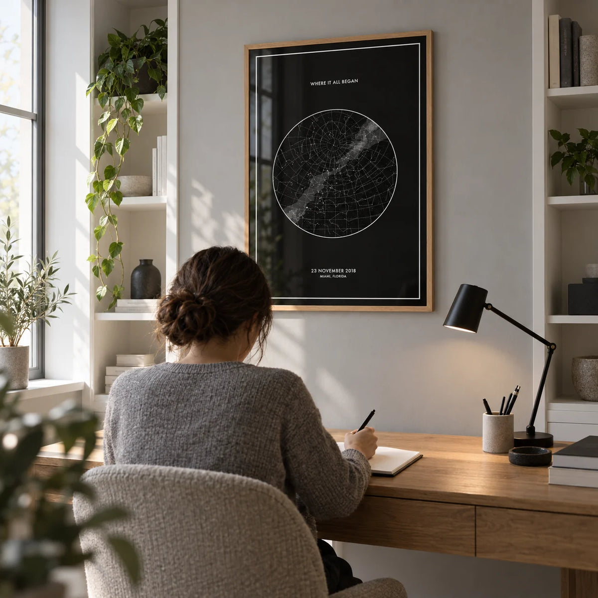 Custom Star Map, framed on the wall of a compact contemporary home study with a soft grey wall and white built-in shelving