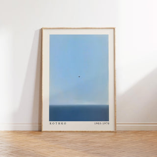 Blue wall art print of a calm ocean and a lone bird in the sky.
