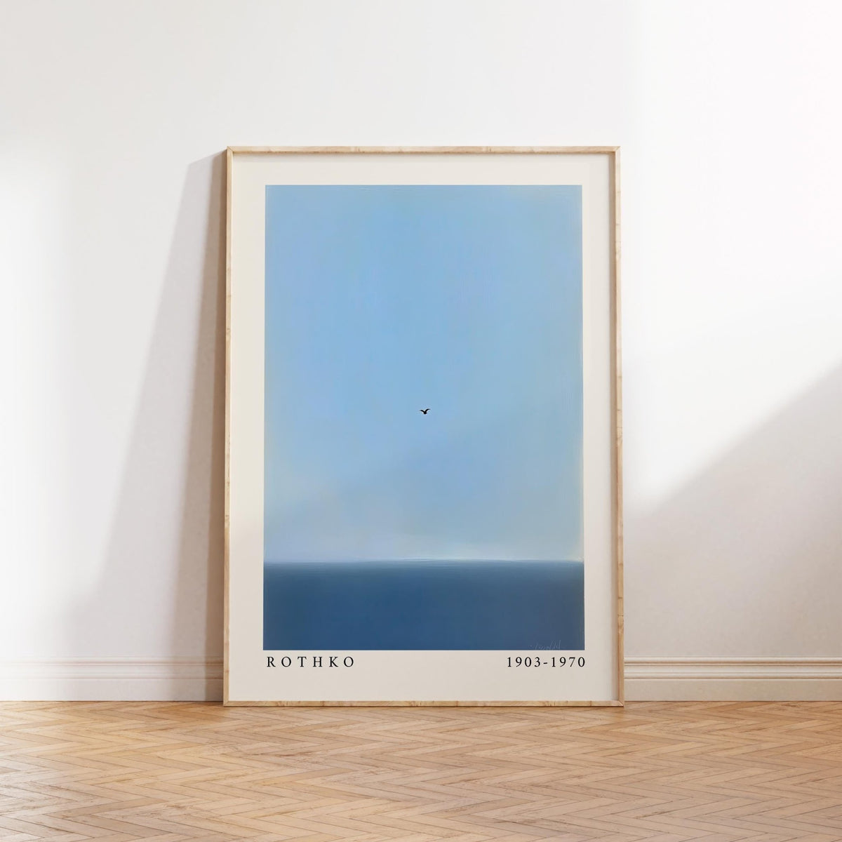 Blue wall art print of a calm ocean and a lone bird in the sky.