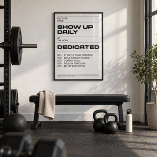 Daily Affirmations Print, framed on the wall of a minimal garage gym with a white painted wall and black rubber floor