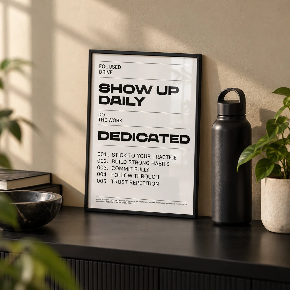 Daily Affirmations Print, a small A4 framed print leaning on a black shelf in a living room
