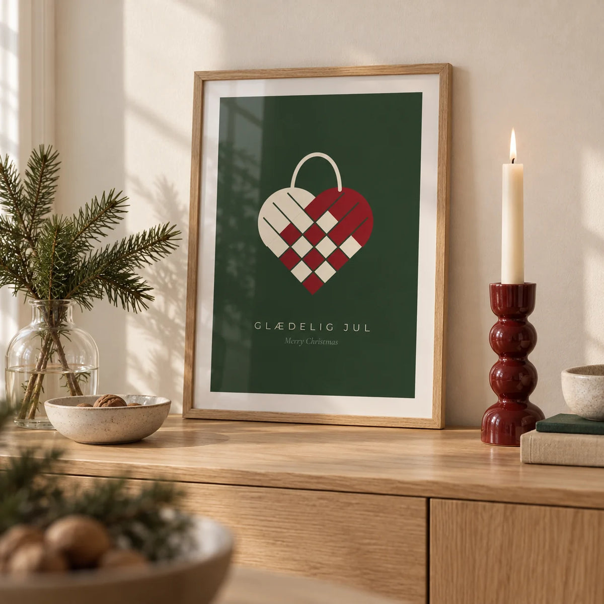 Danish Christmas Print, a small A4 framed print leaning on a pale oak sideboard in a living room