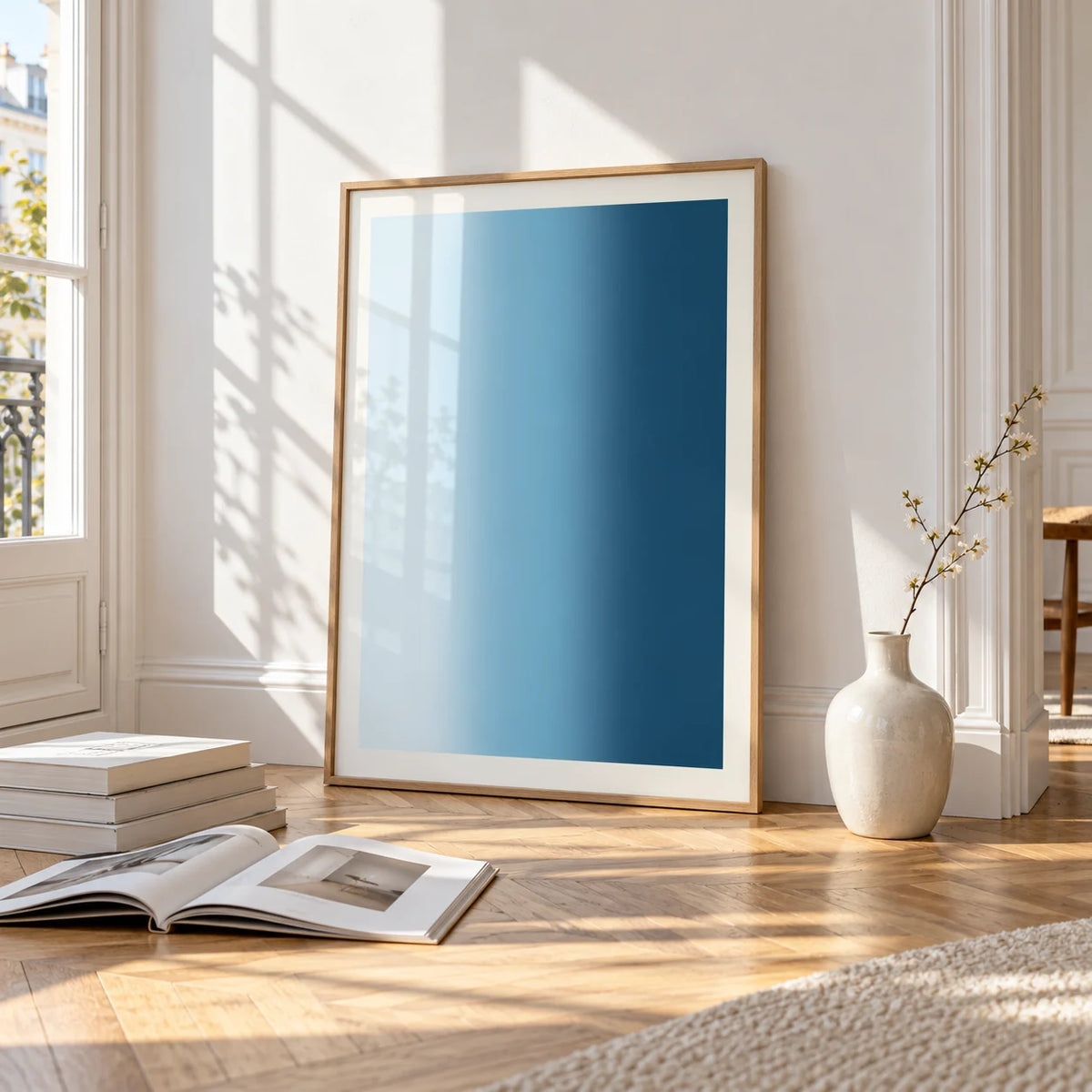 Dark Blue Wall Art, framed and leaning on the parquet floor of a bright living room
