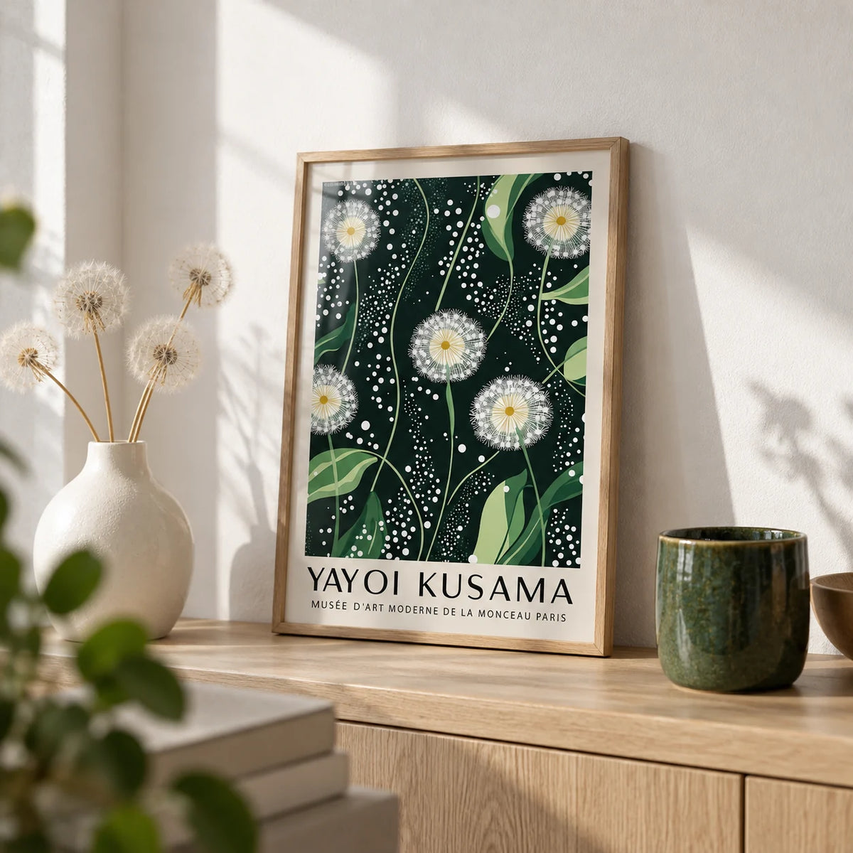 Yayoi Kusama Dandelions: Dark Green Wall Art, a small A4 framed print leaning on a pale oak shelf in a living room