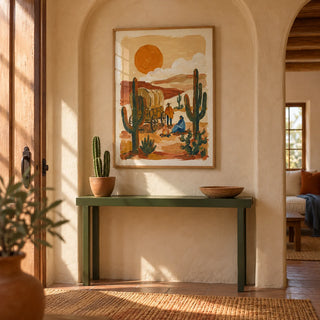 Desert Wagon Art Print, framed on the wall of a adobe-style hallway with an arched plaster niche