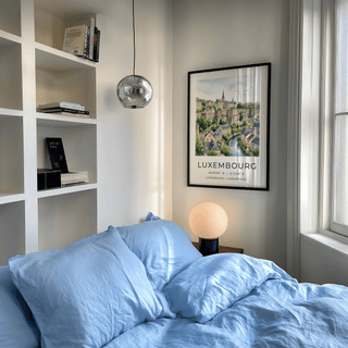 City illustration wall art with stone ramparts, clustered houses, and open sky