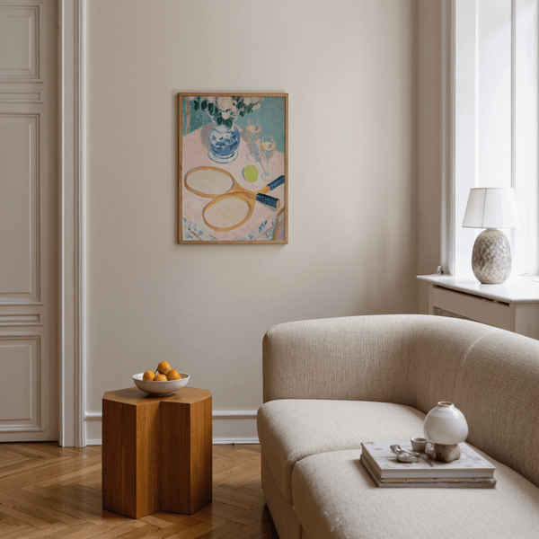 Close-up print poster showing two tennis rackets overlapping on a pink tabletop