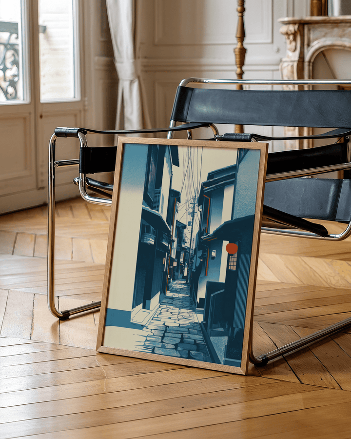 Print of Japanese Street Wall Art with a narrow Kyoto street and blue tones leaning on a chair