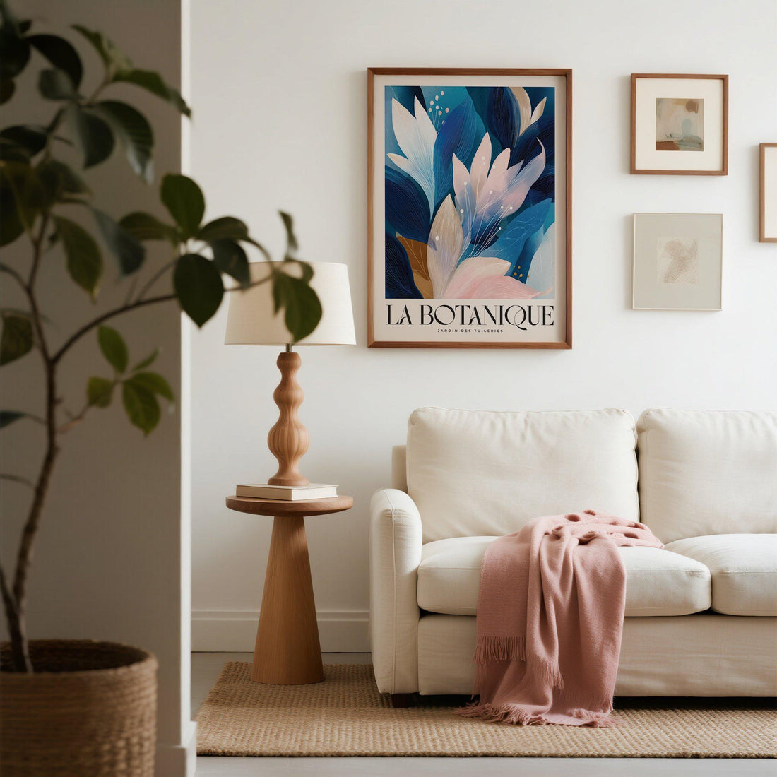 Blue and blush botanical print above a cream sofa with a pink throw in a light living room