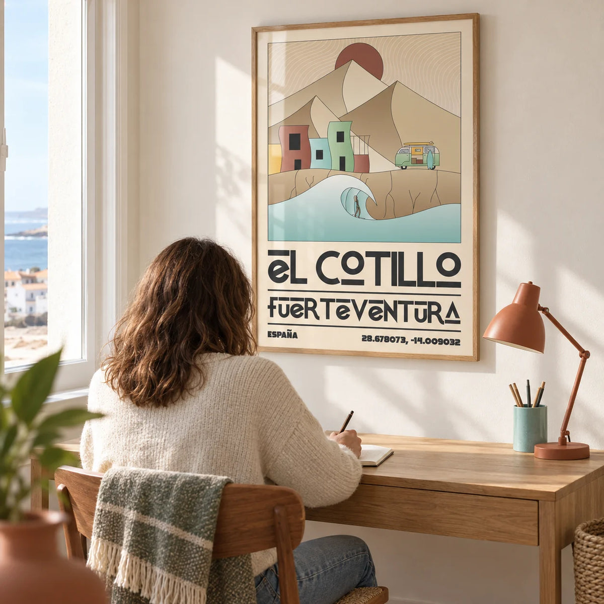 El Cotillo Surfing Poster, framed on the wall of a bright home study in a UK seaside terrace with a warm white wall and a simple oak desk