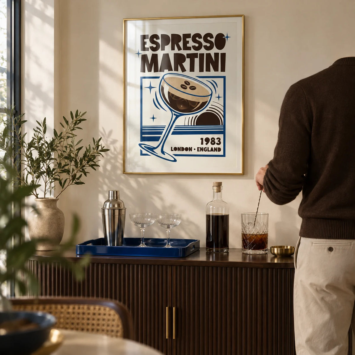 Espresso Martini Print, framed on the wall of a compact home bar alcove in a stylish UK flat with a cream wall and a dark brown fluted drinks cabinet in a living room