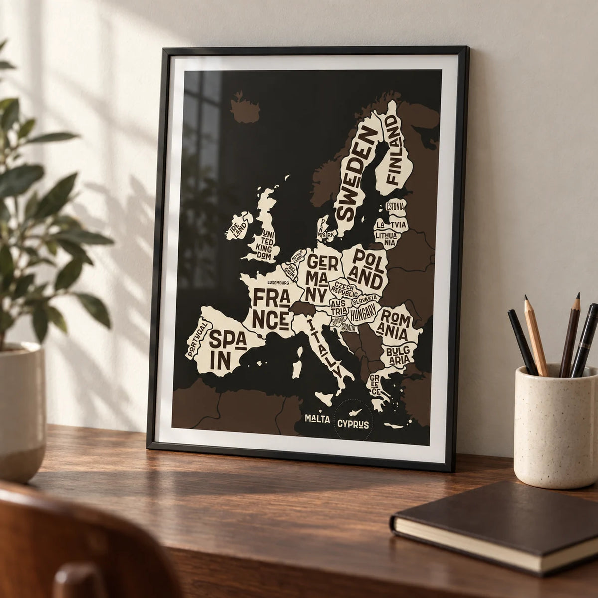 Europe Poster, a small A4 framed print leaning on a walnut desk