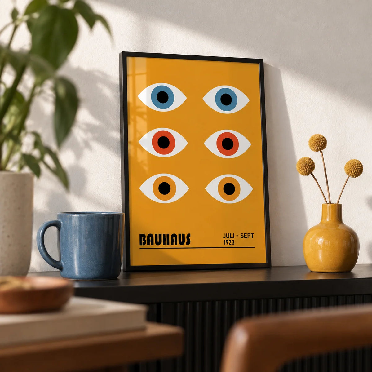Eye Poster, a small A4 framed print leaning on a black shelf in a living room
