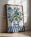 Olive tree wall art with blue and green branches in a striped ceramic vase.
