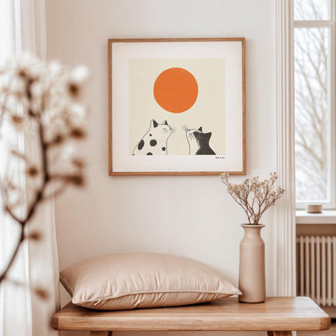 Two cats looking at an orange sun poster.