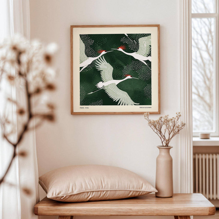 White Crane Birds Art print of white cranes with red crests on a dark green background above a vase with dried flowers