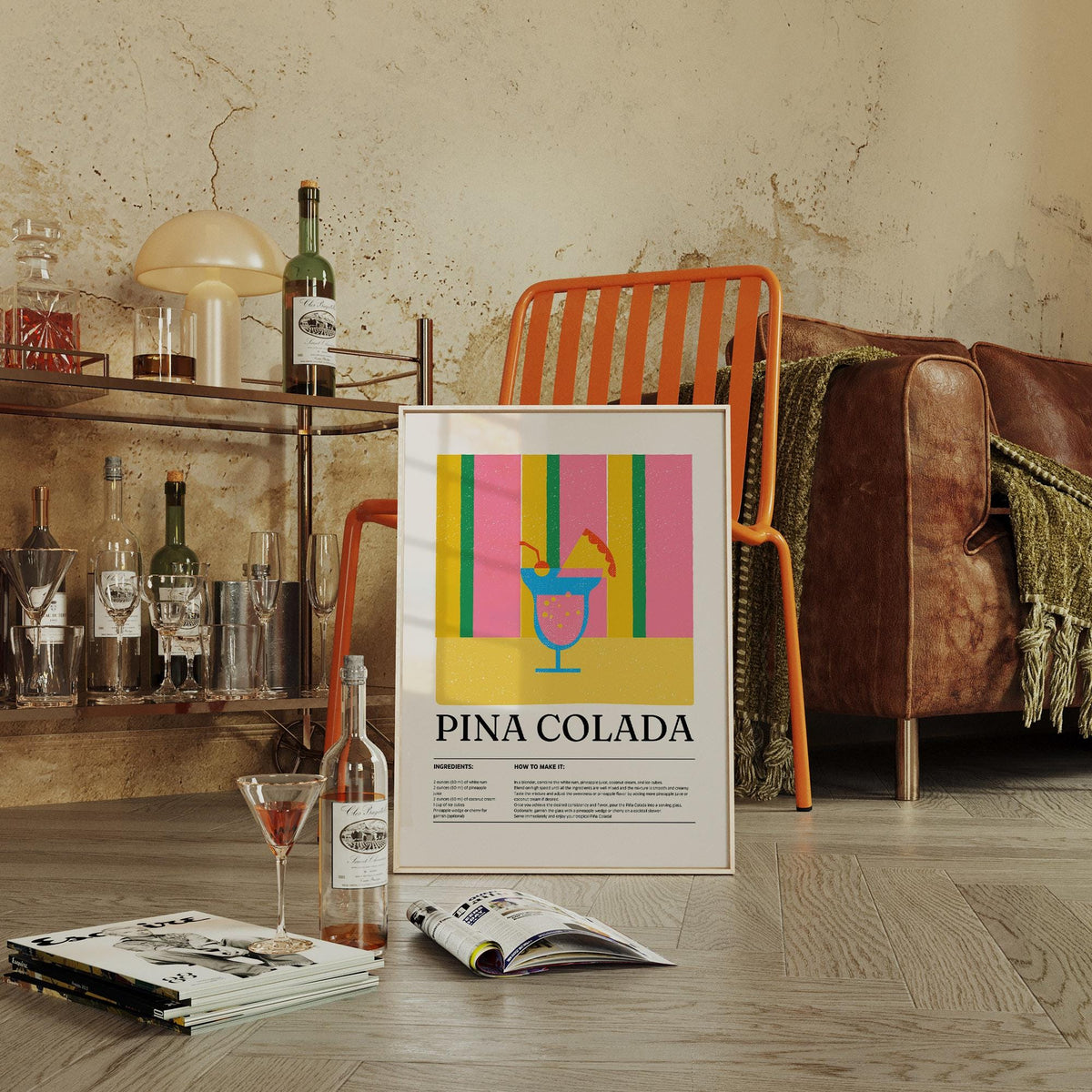 Print leaning on a floor showing a minimalist piña colada cocktail design with stripes in pink green and yellow near an orange chair