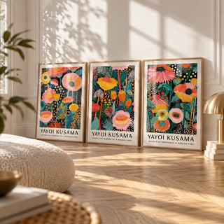 Floral Prints Set of 3 styled leaning on a herringbone floor between a boucle cushion and a brass mushroom lamp: Petal Paradise, Lush Tropica and Botanical Glow shown framed side by side (frames not included)