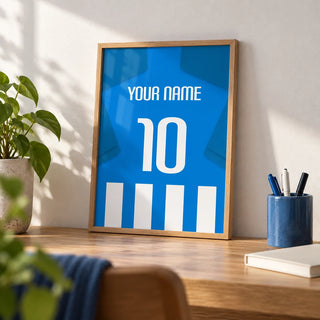 Football Shirt Poster in Blue and White Stripes with Blue Sleeves, a small A4 framed print leaning on an oak desk