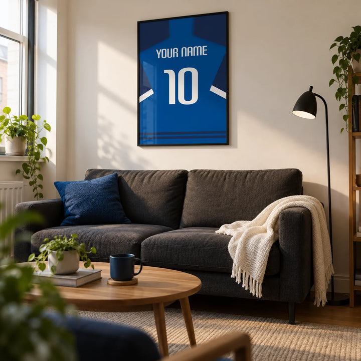 Football Shirt Poster in Blue with Dark Sleeves and White Stripe, framed on the wall of a compact modern living room in a football fan's first UK flat (22-28)