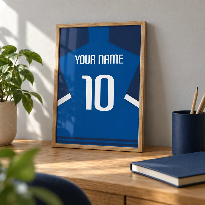 Football Shirt Poster in Blue with Dark Sleeves and White Stripe, a small A4 framed print leaning on an oak desk